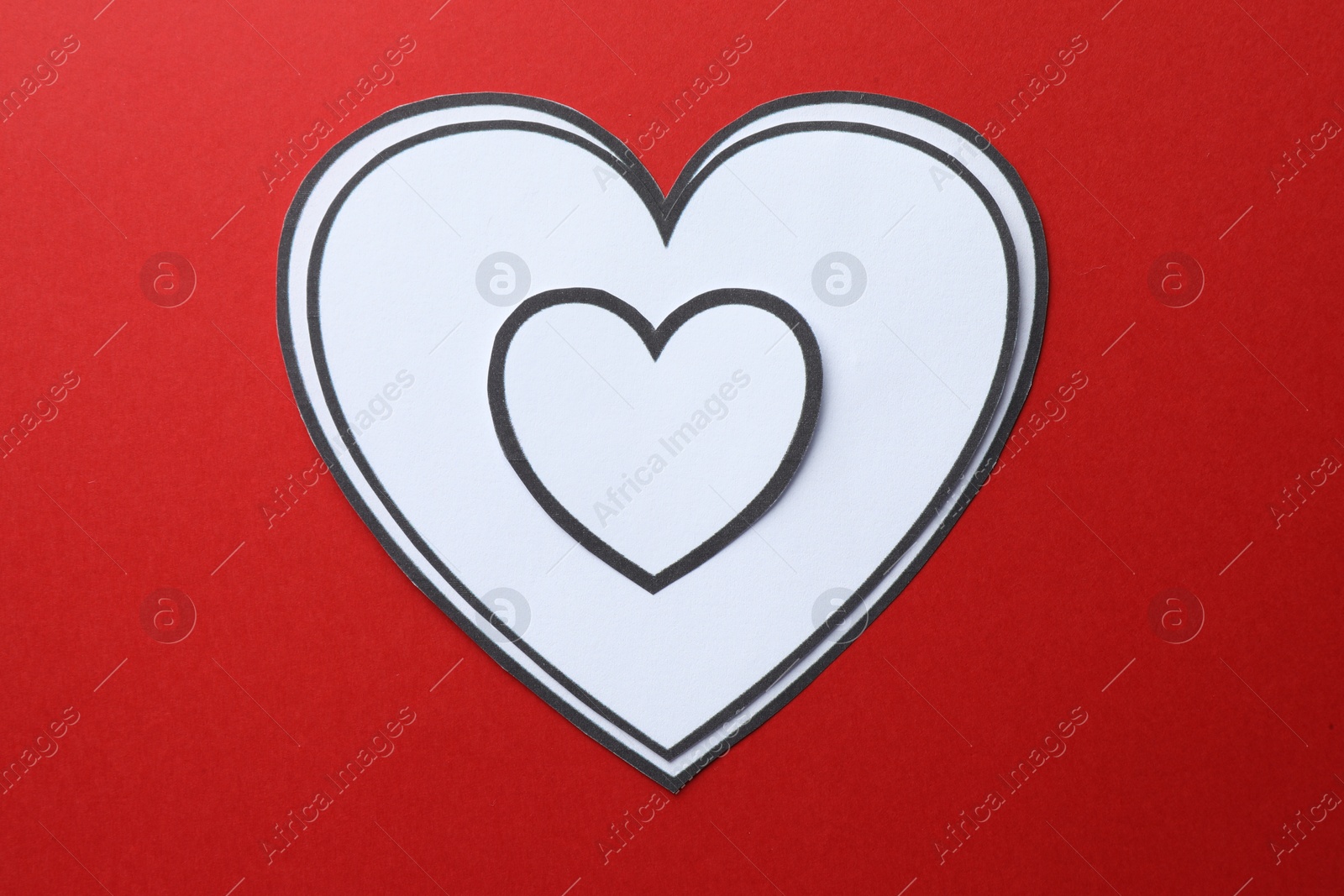 Photo of Paper hearts on red background, top view