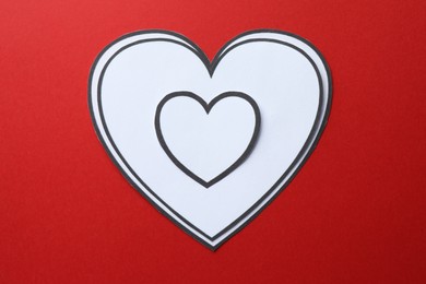 Photo of Paper hearts on red background, top view