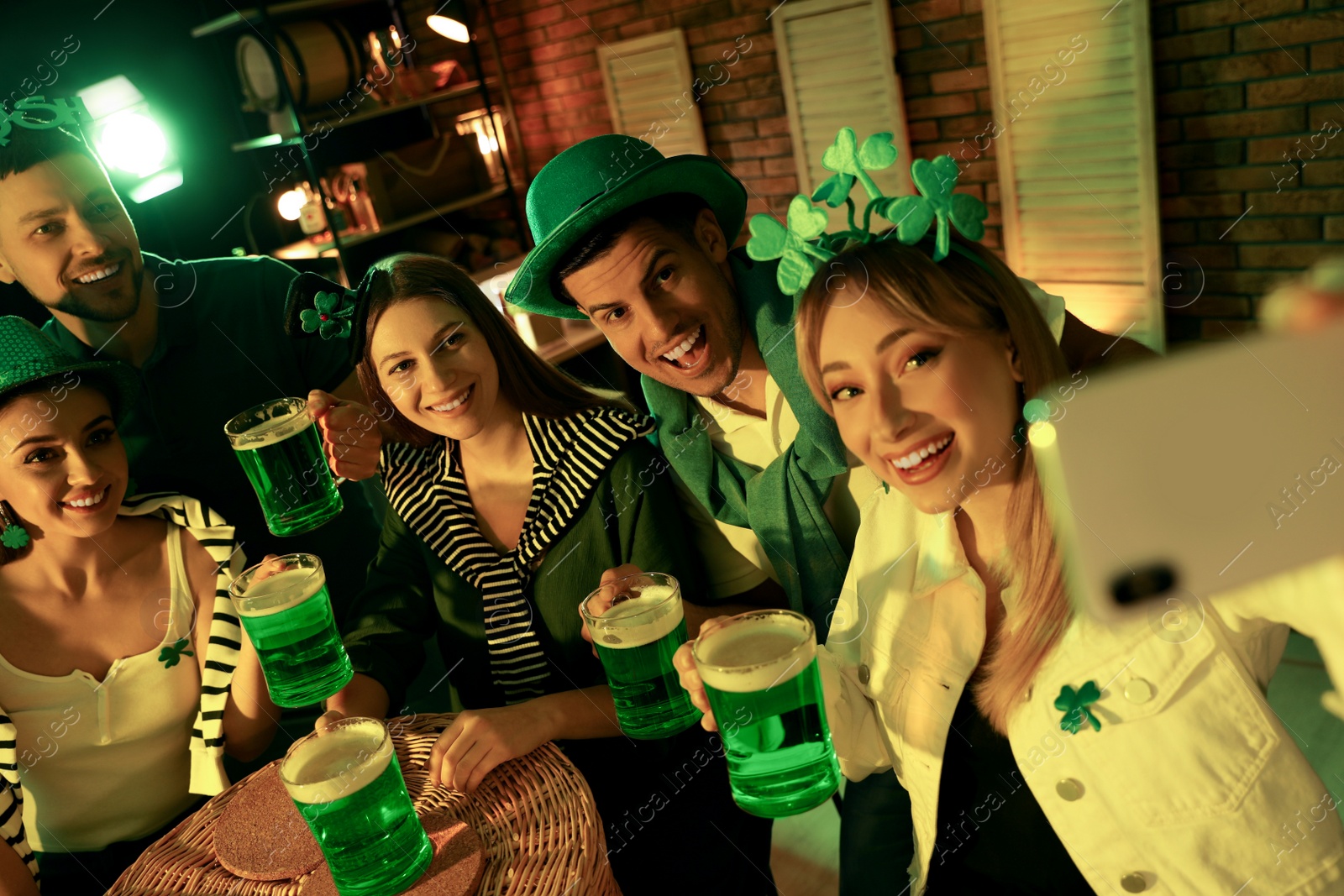 Photo of People with beer taking selfie in pub. St Patrick's day celebration