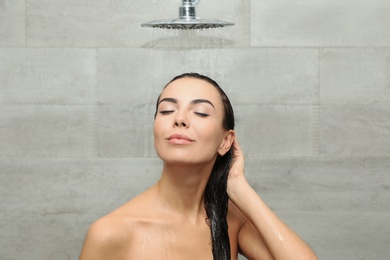 Photo of Beautiful young woman taking shower in spa center