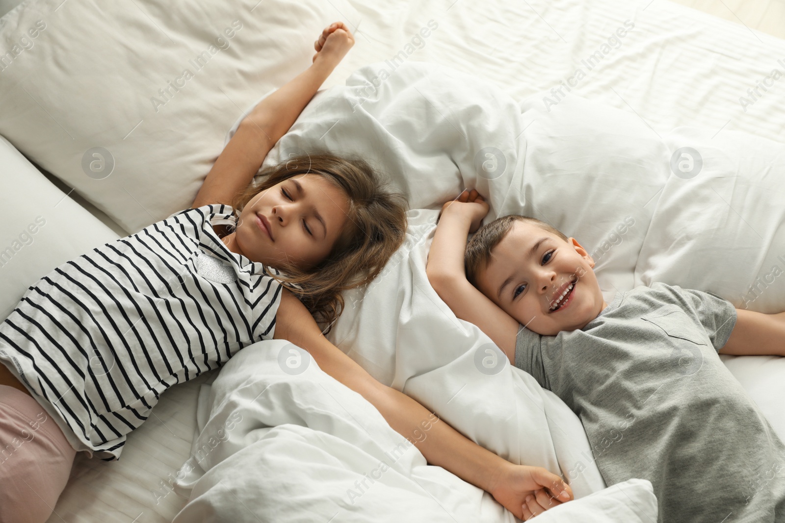 Photo of Cute little children on bed, above view. Healthy sleep