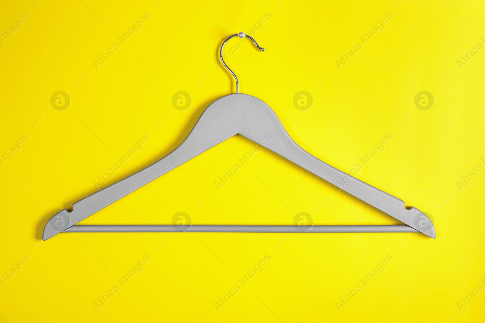 Photo of Empty clothes hanger on color background. Wardrobe accessory