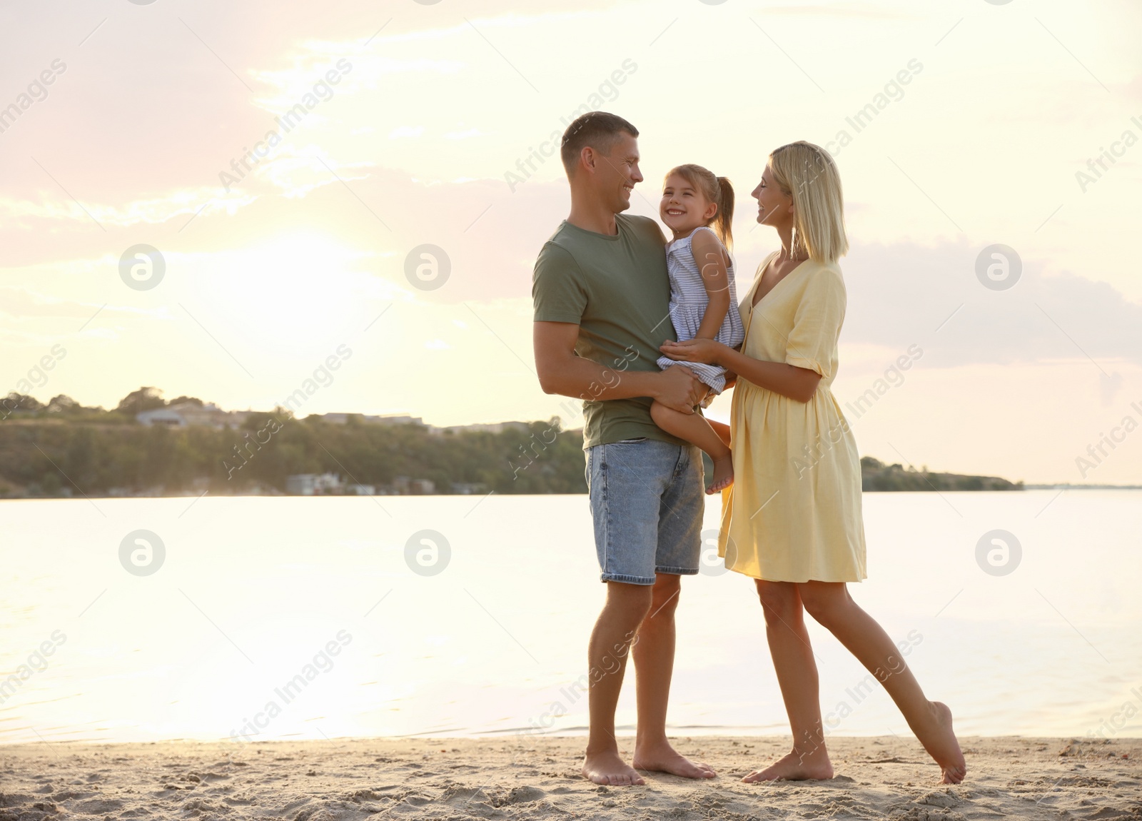 Photo of Happy parents with their child on beach, space for text. Spending time in nature