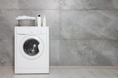 Photo of Empty laundry room with modern washing machine, space for text. Interior design