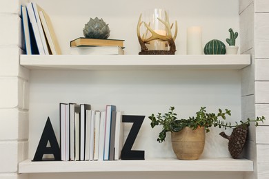 Photo of Bookends and other decor on shelves indoors. Interior design