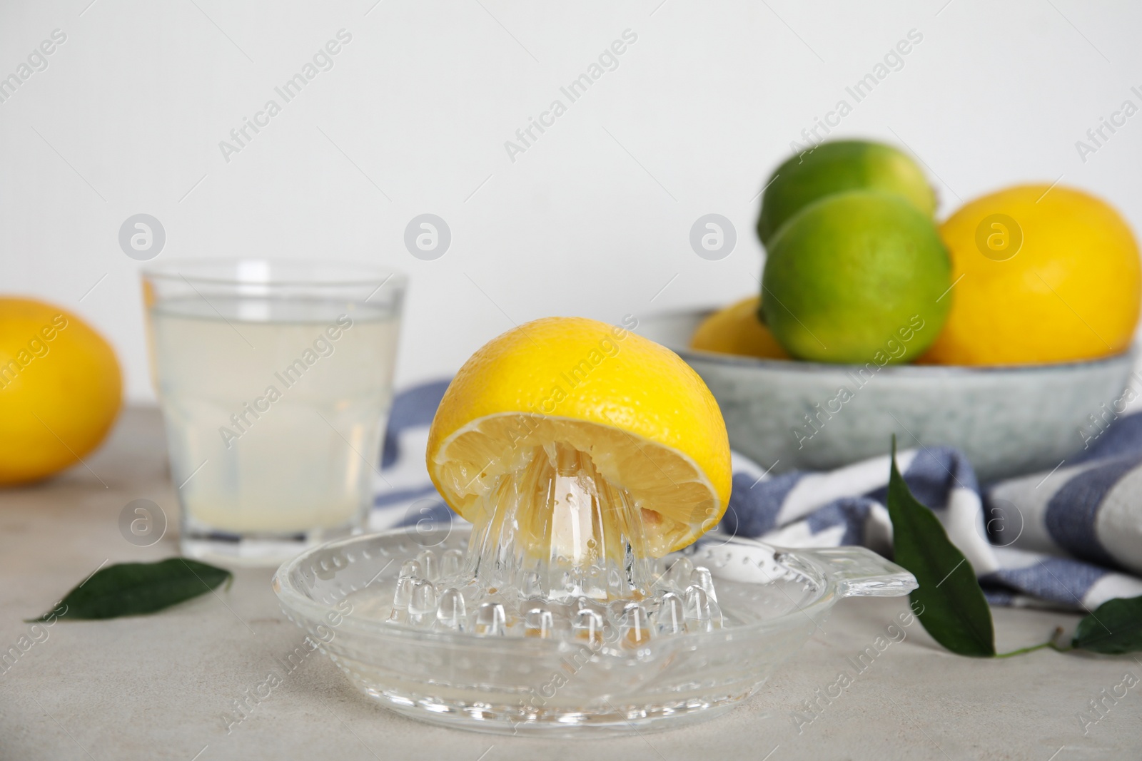 Photo of Glass squeezer with lemon and juice on light table