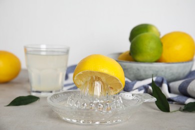 Photo of Glass squeezer with lemon and juice on light table