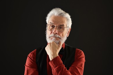 Senior man with mustache on black background