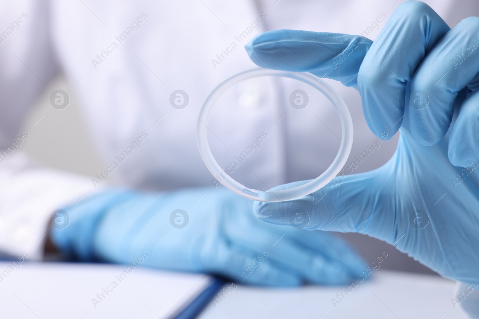 Photo of Doctor holding diaphragm vaginal contraceptive ring at table, closeup