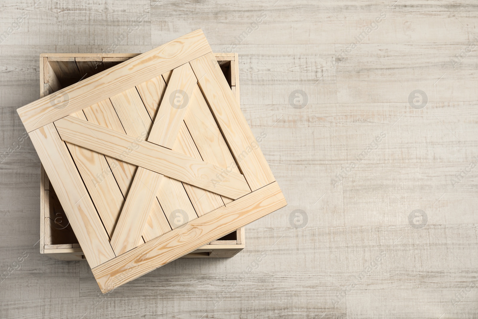 Photo of Wooden crate with lid on light background, top view. Space for text