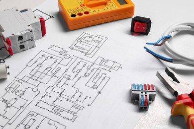 Photo of Wiring diagrams and different electrician's equipment on white table