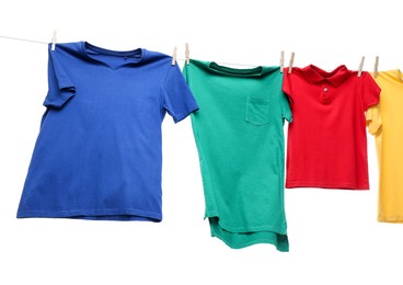 Photo of Colorful t-shirts drying on washing line isolated on white