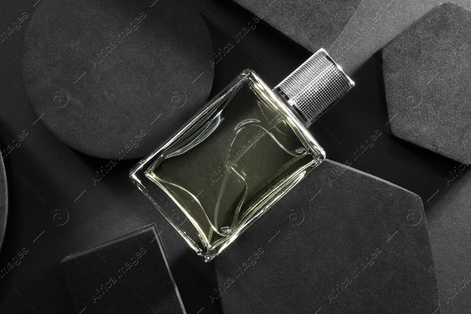 Photo of Stylish presentation of luxury men`s perfume in bottle on black background, top view