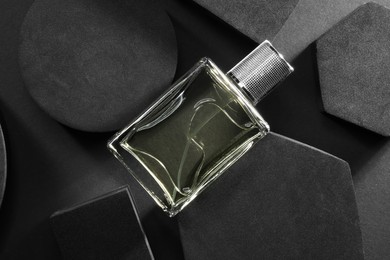 Stylish presentation of luxury men`s perfume in bottle on black background, top view