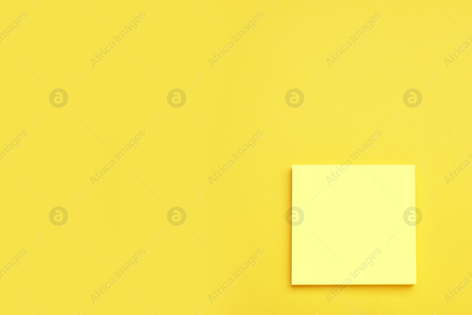 Photo of Paper note on yellow background, top view. Space for text