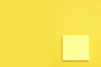 Photo of Paper note on yellow background, top view. Space for text
