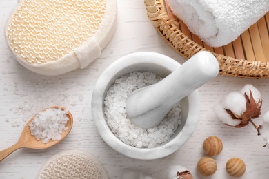 Photo of Flat lay composition with sea salt on white wooden background. Spa treatment