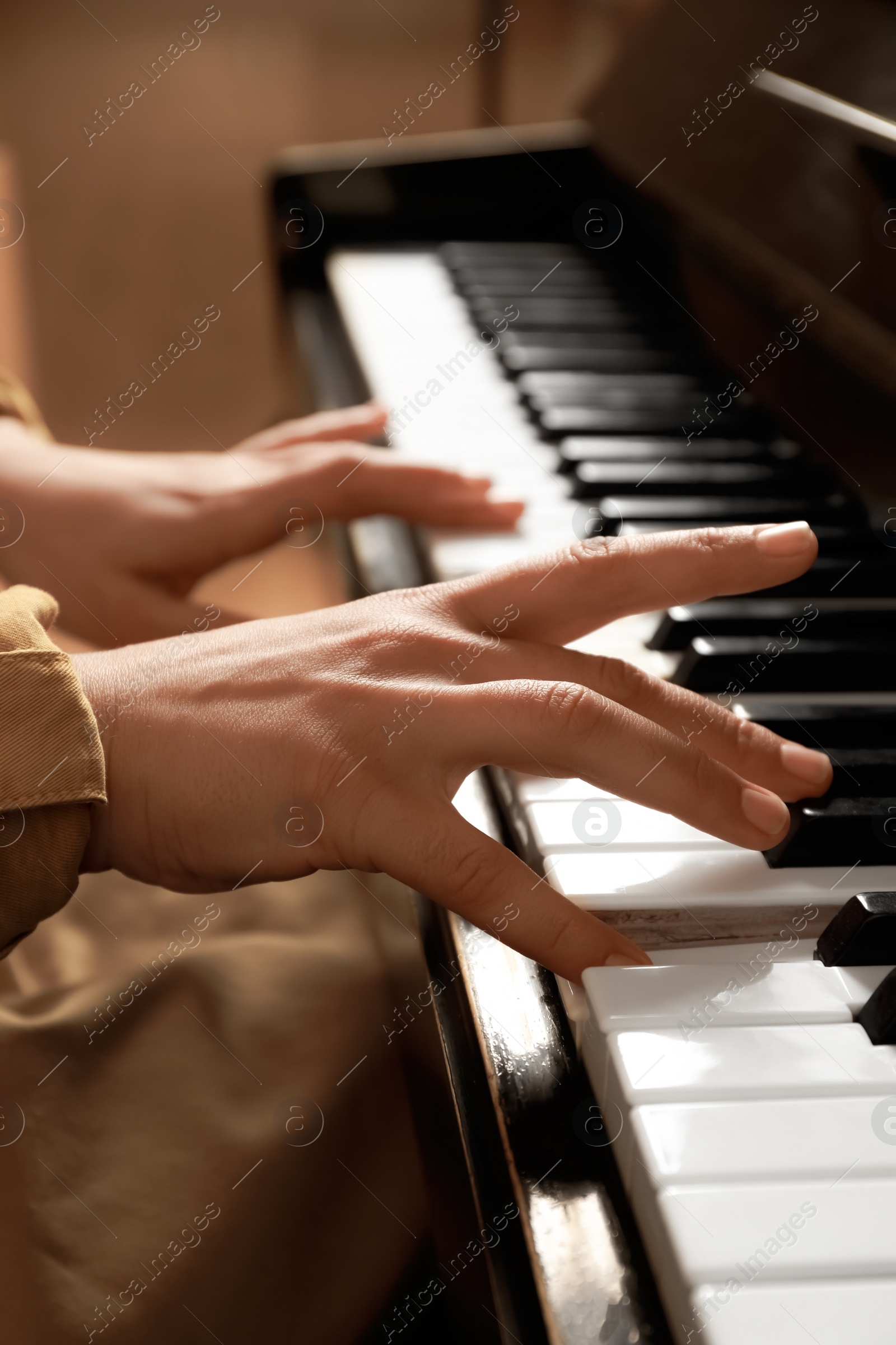 Photo of Young woman playing piano, closeup. Music lesson