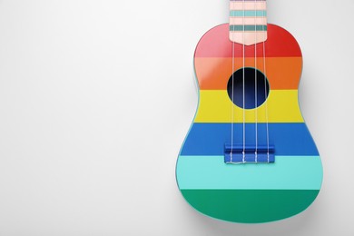 Colorful ukulele on white background, top view and space for text. String musical instrument