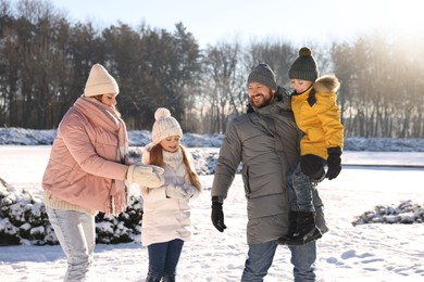 Happy family spending time together in sunny snowy park