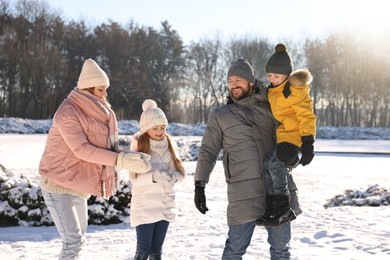 Photo of Happy family spending time together in sunny snowy park