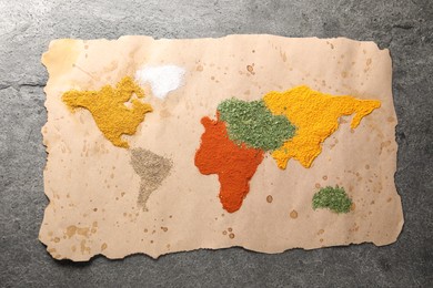 Photo of World map of different spices on grey table, top view