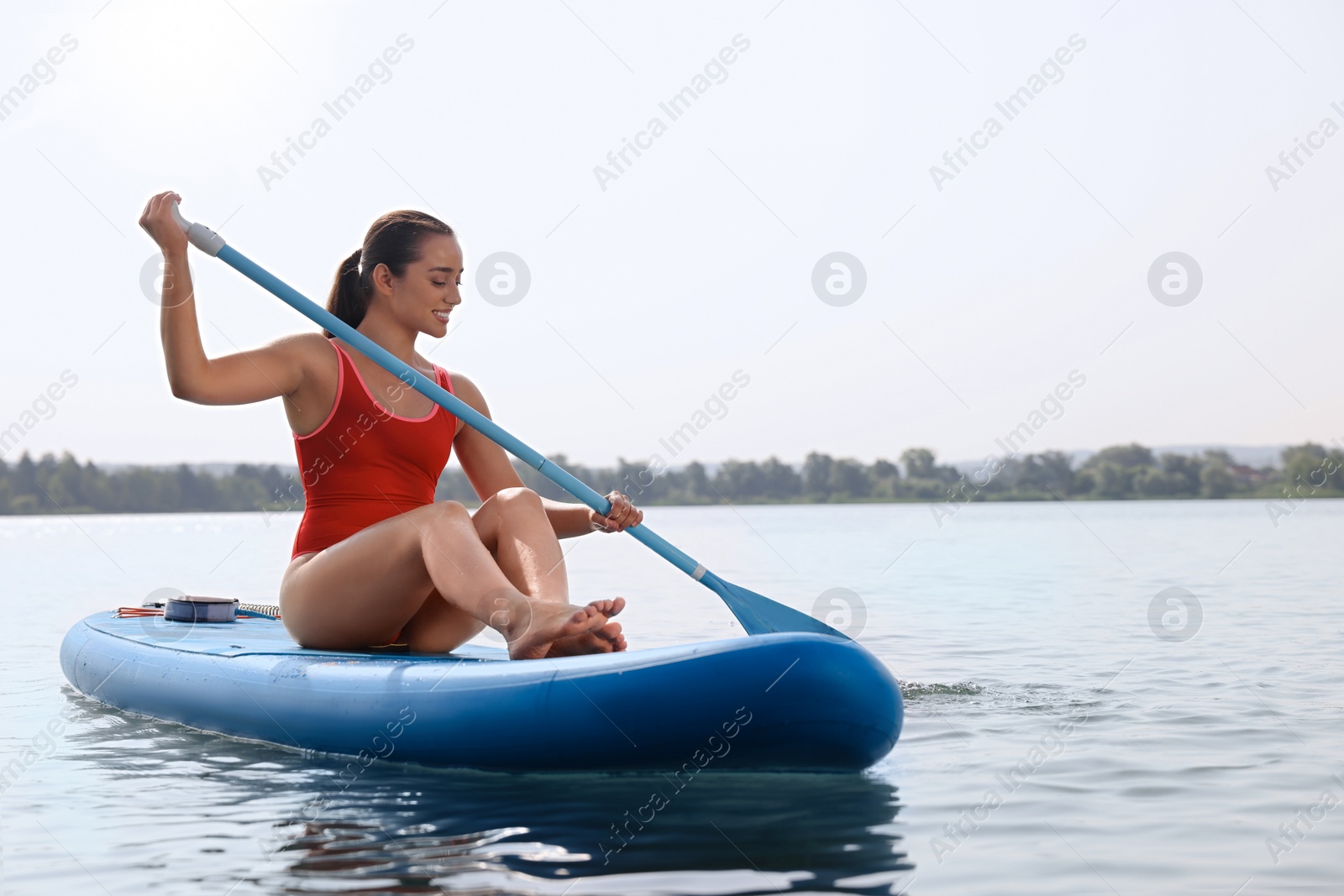Photo of Woman paddle boarding on SUP board in sea, space for text