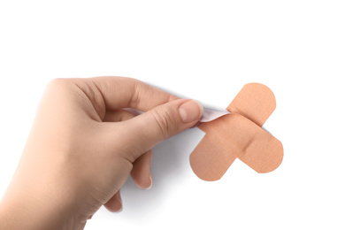 Photo of Woman putting sticking plaster on white background, top view. First aid item