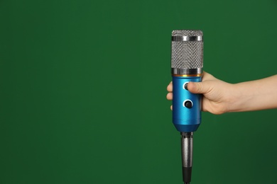Photo of Child holding microphone on color background, closeup. Space for text
