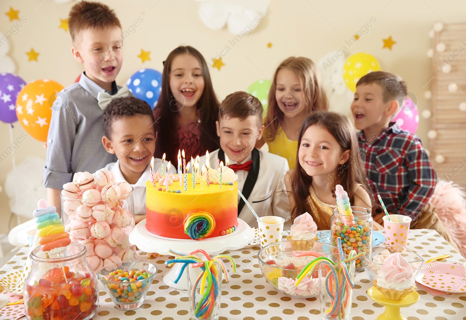 Photo of Cute children celebrating birthday at table indoors