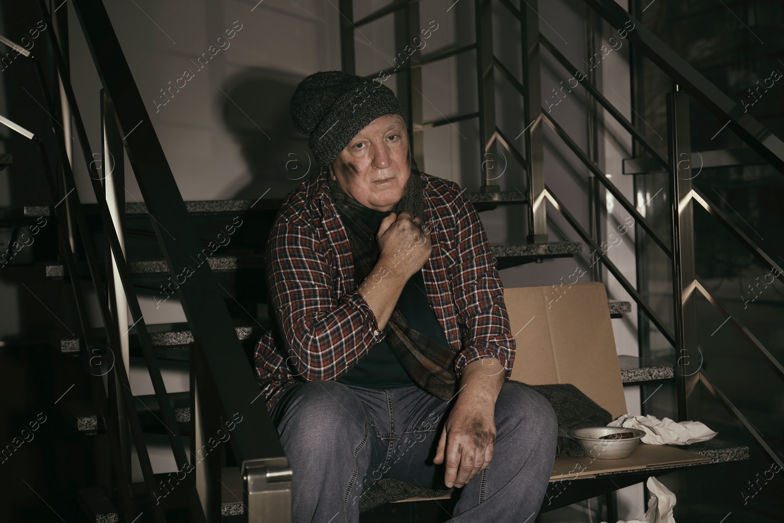Photo of Poor senior man sitting on stairs indoors