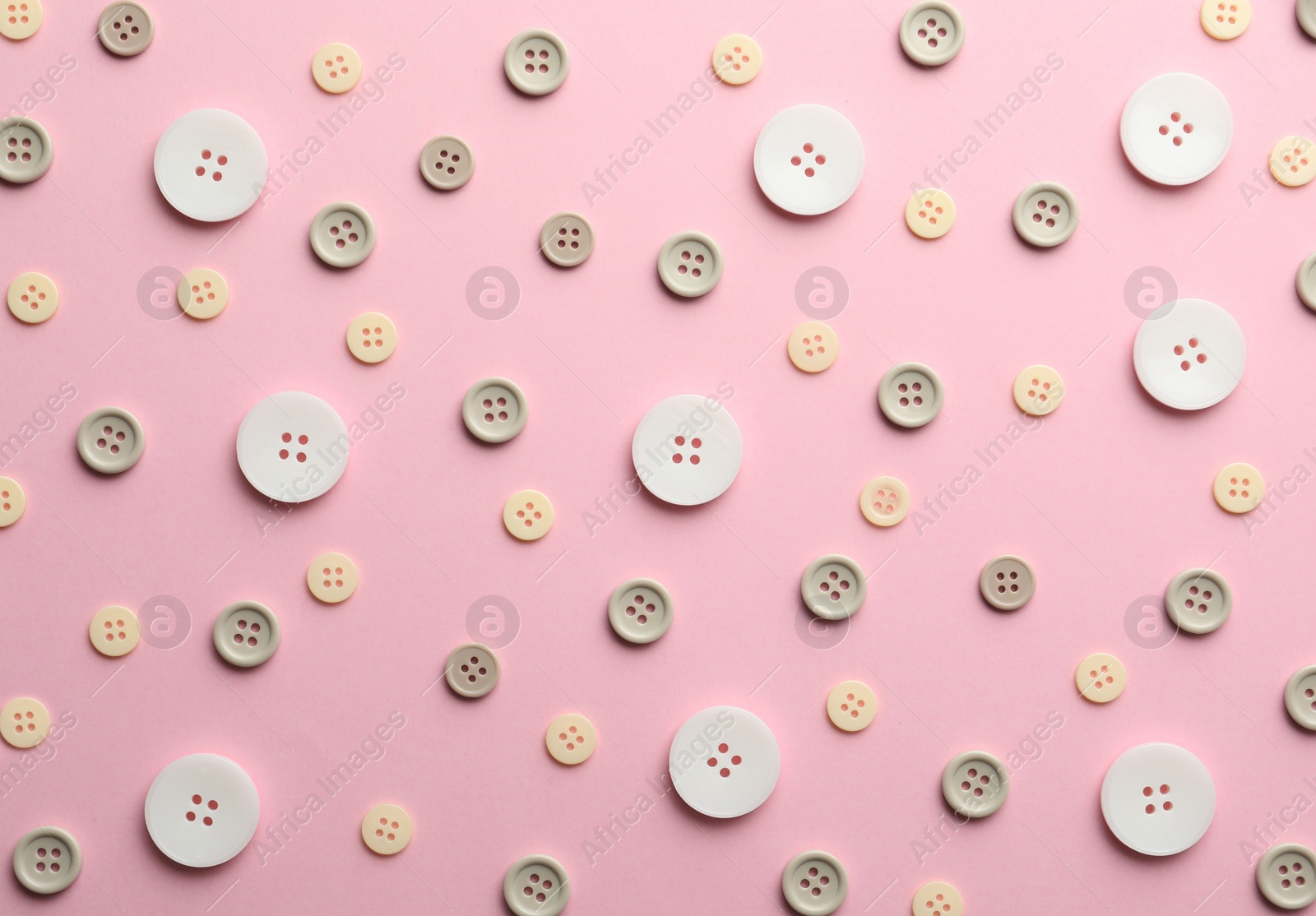 Photo of Different sewing buttons on pink background, flat lay