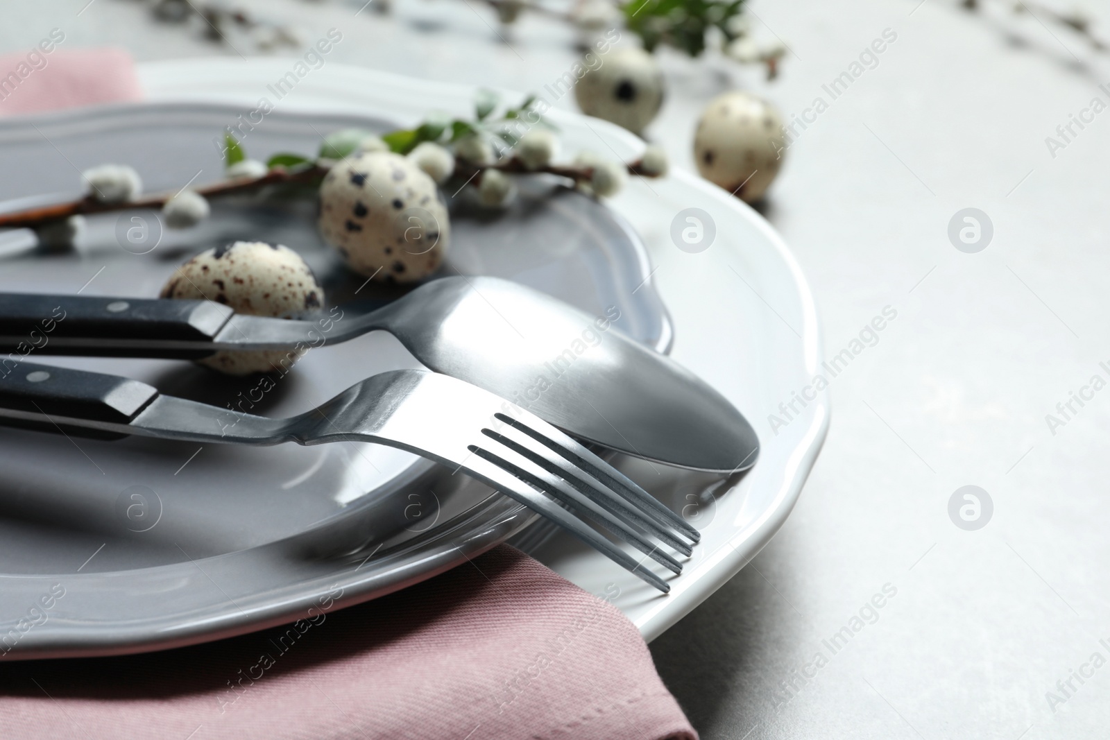 Photo of Festive Easter table setting with quail eggs on color background, closeup. Space for text