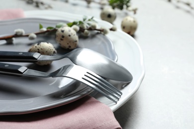 Festive Easter table setting with quail eggs on color background, closeup. Space for text