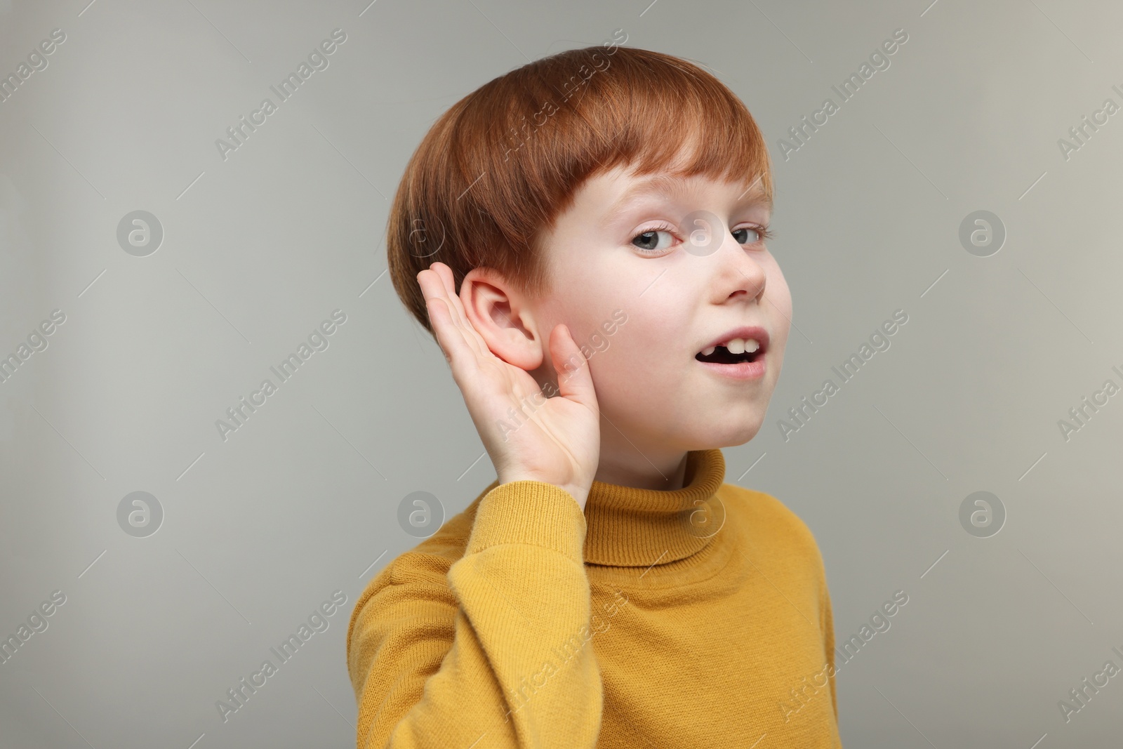 Photo of Little boy with hearing problem on grey background