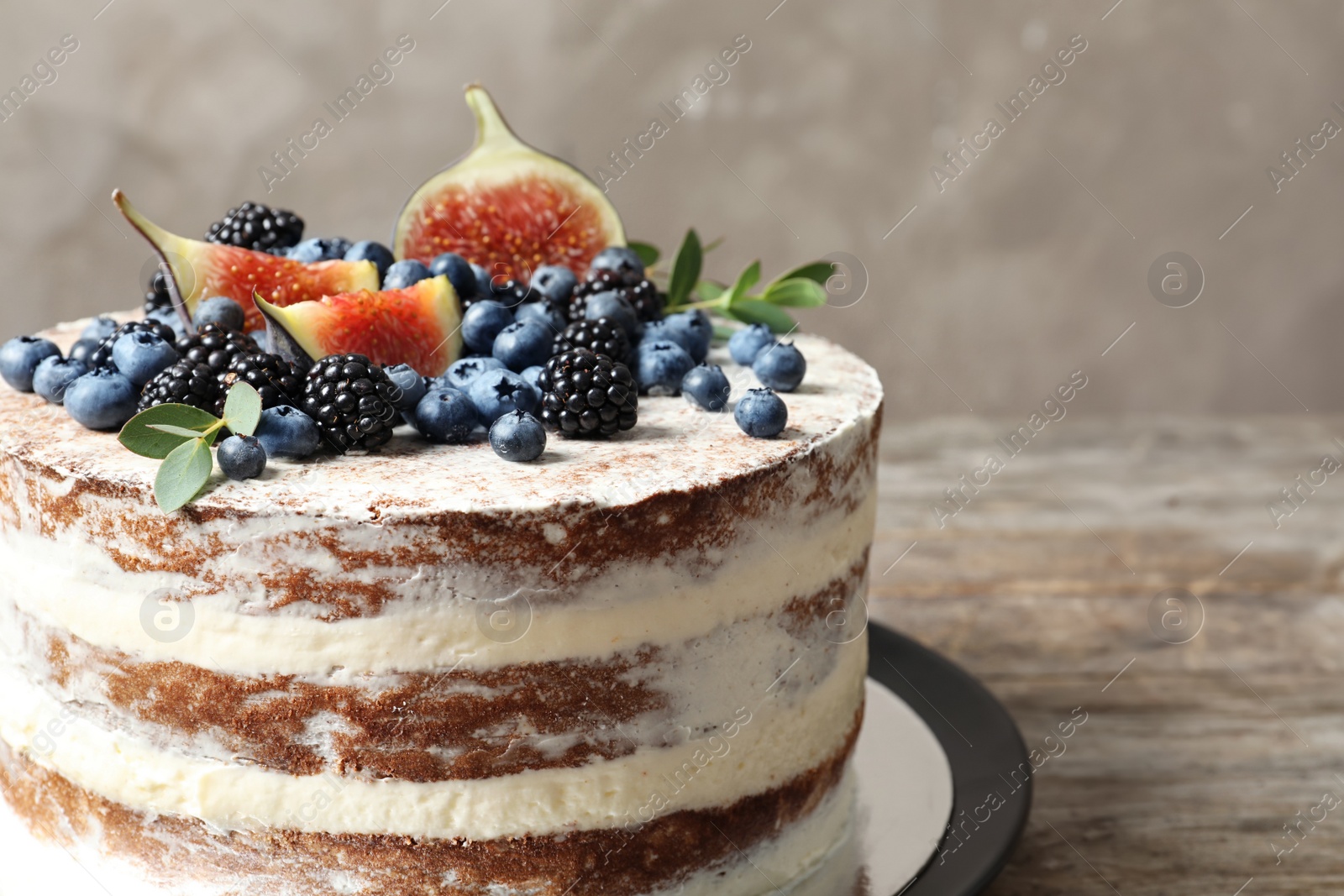 Photo of Delicious homemade cake with fresh berries on wooden table, closeup