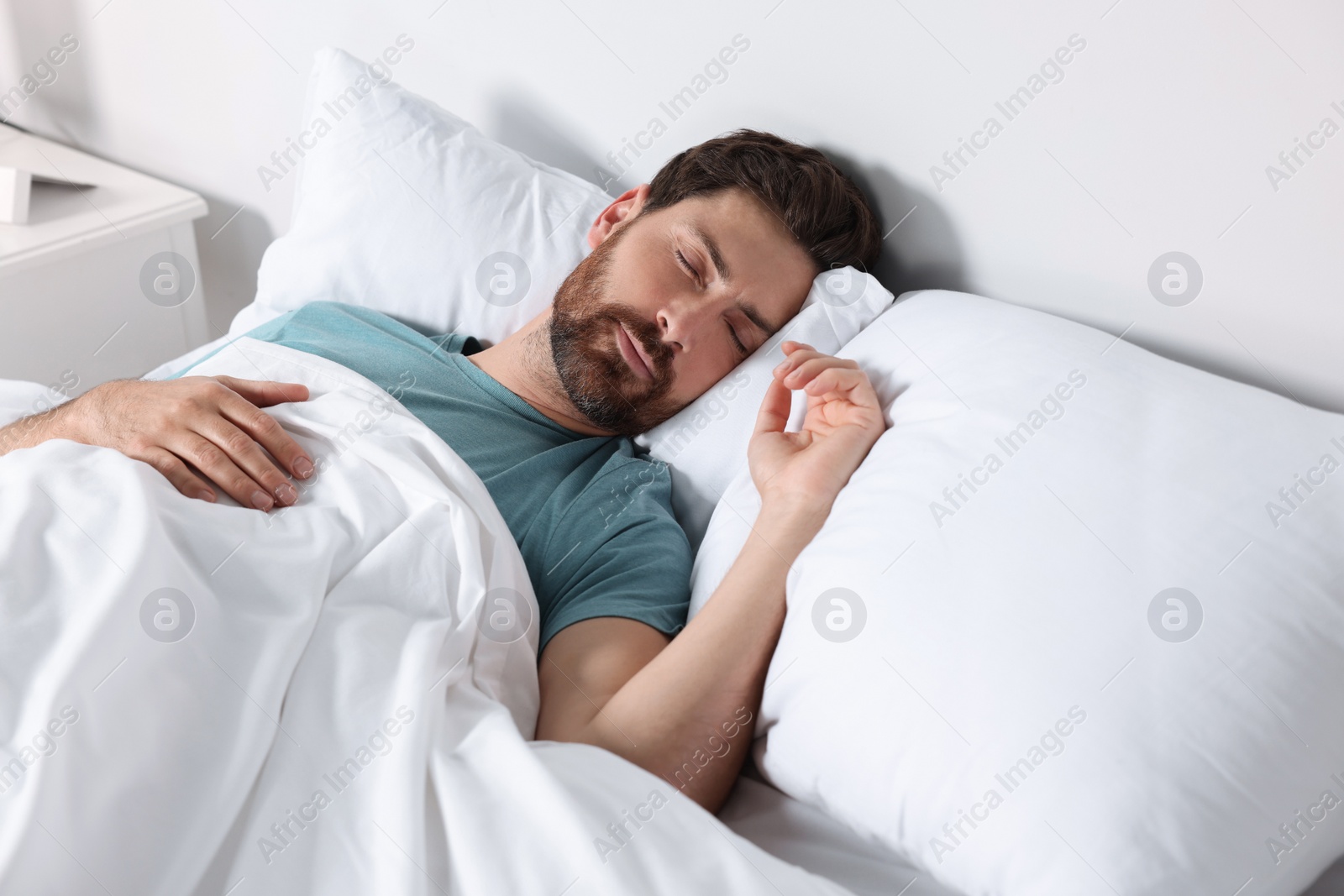 Photo of Man sleeping on comfortable pillows in bed at home