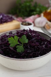 Photo of Tasty red cabbage sauerkraut with parsley on white wooden table