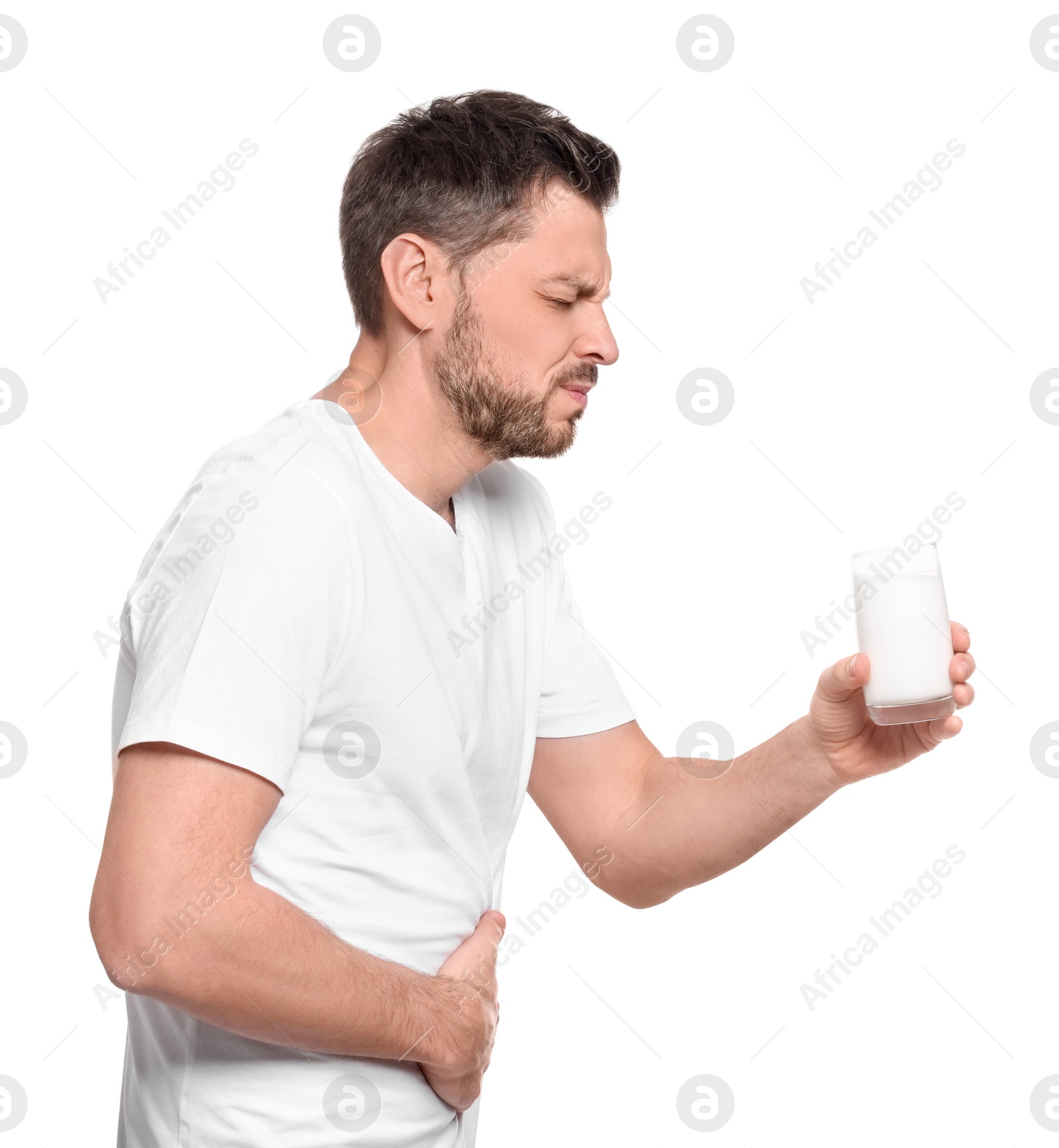 Photo of Man with glass of milk suffering from lactose intolerance on white background