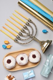Flat lay composition with Hanukkah menorah and gift boxes on light grey background