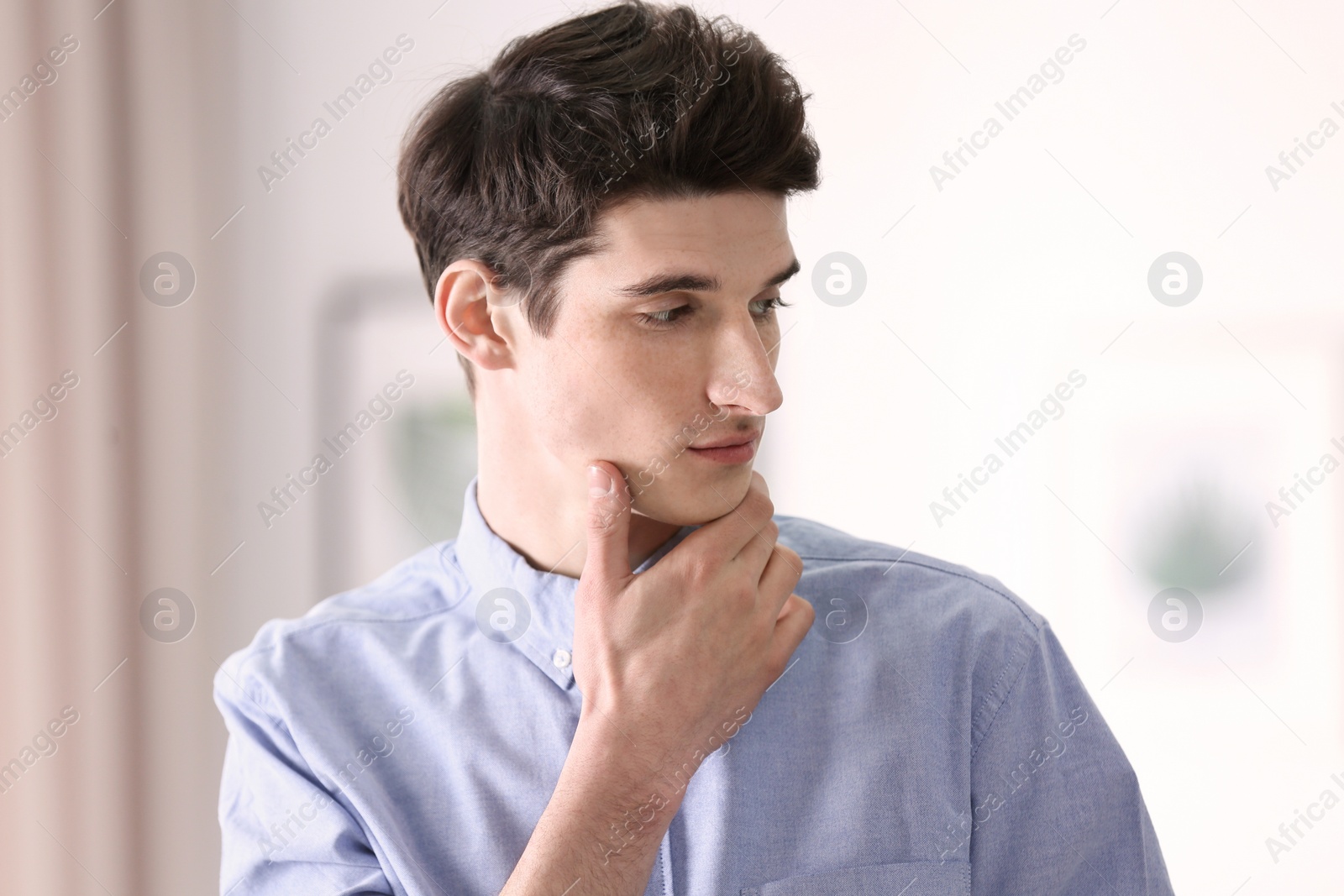 Photo of Portrait of young man with beautiful hair indoors