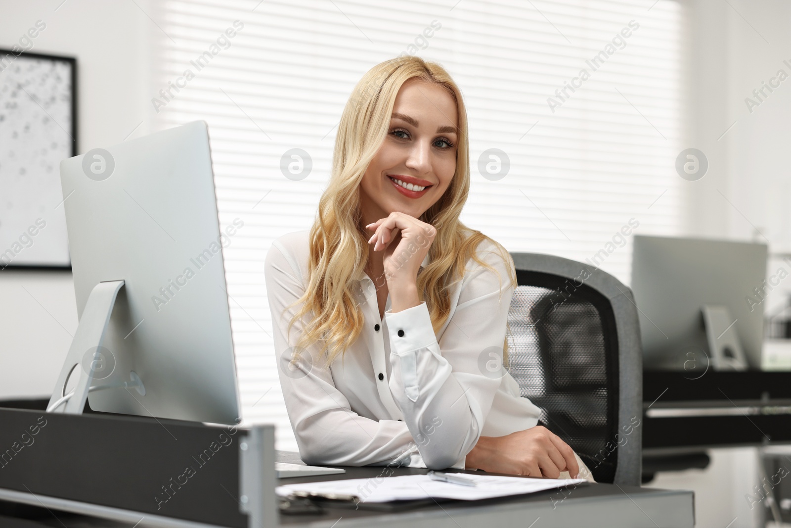 Photo of Portrait of happy secretary at table in office