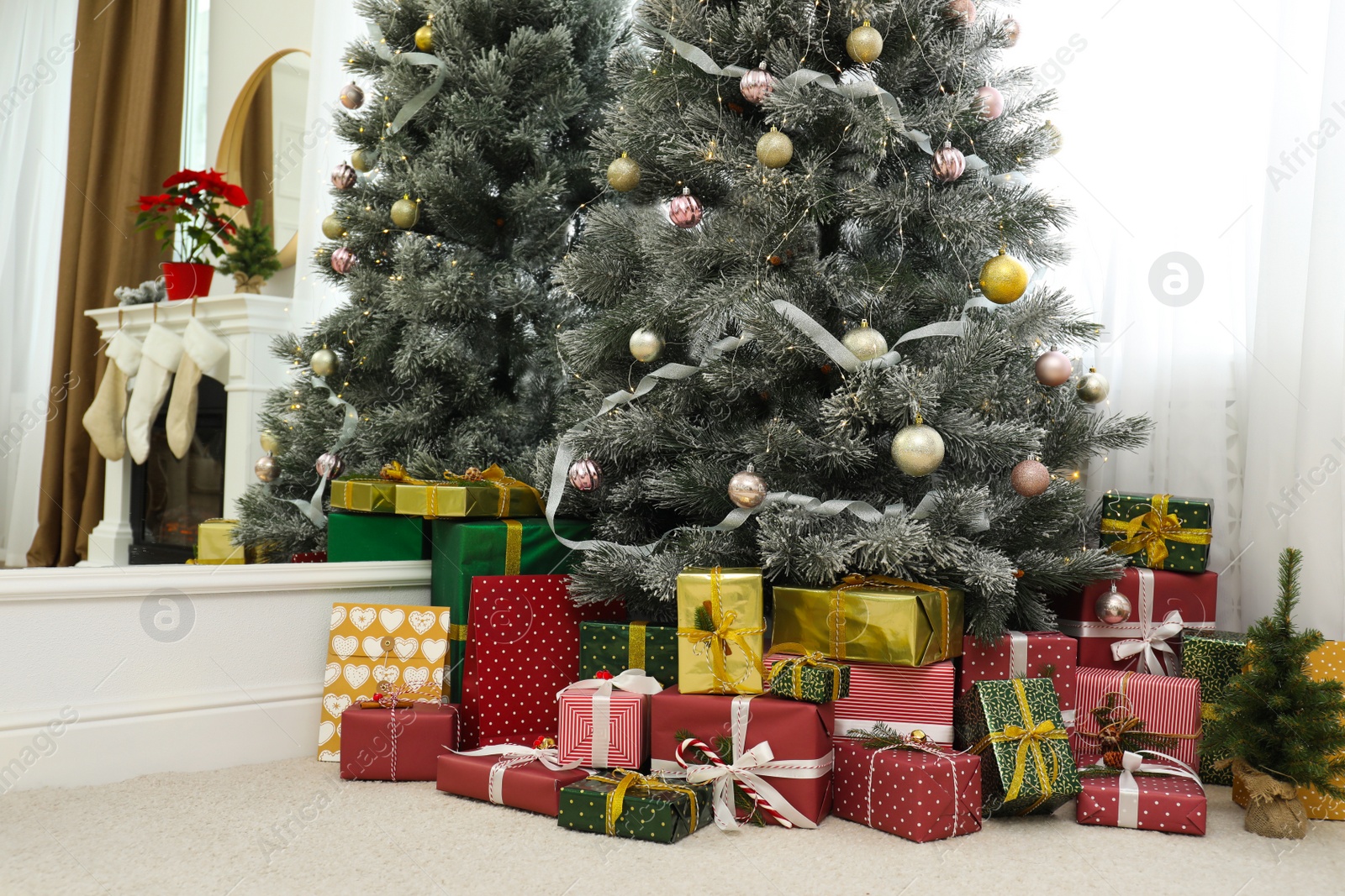 Photo of Many different gifts under Christmas tree indoors