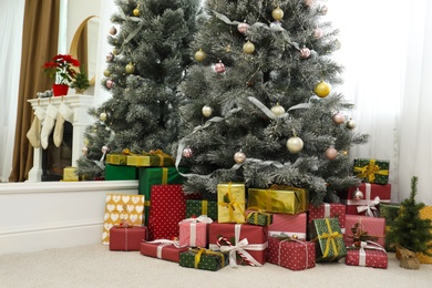 Many different gifts under Christmas tree indoors