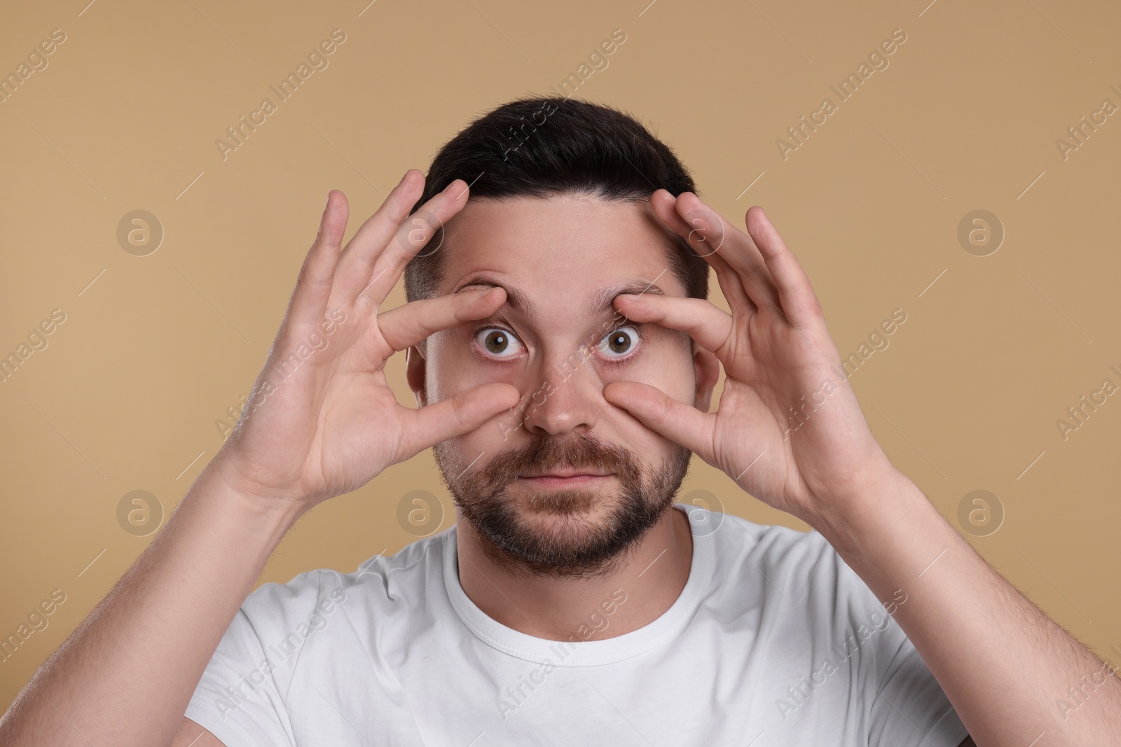 Photo of Sleepy man on beige background. Insomnia problem