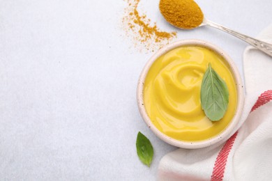 Photo of Tasty curry sauce, powder and basil leaves on light table, flat lay. Space for text