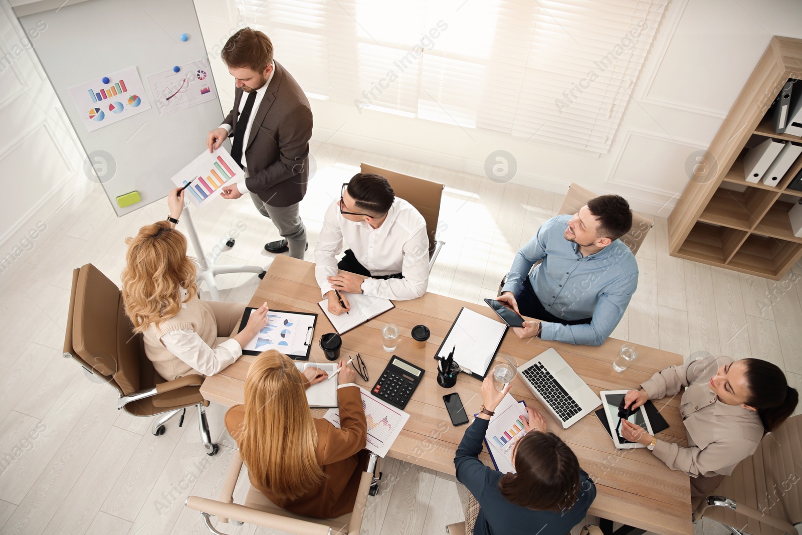 Photo of Businesspeople having meeting in office, above view. Management consulting