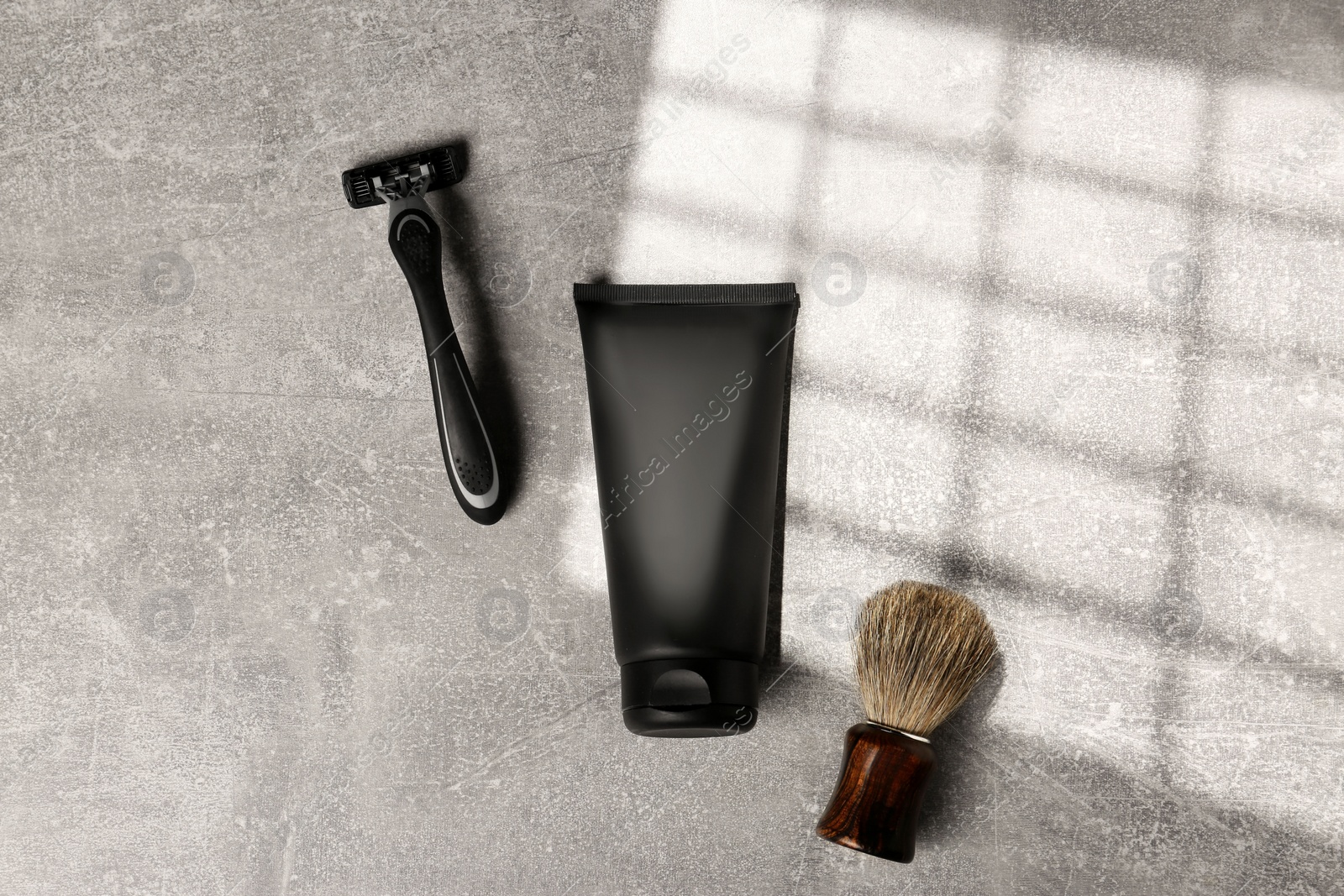 Photo of Set of men's shaving tools on light gray textured table, flat lay