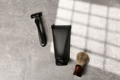 Photo of Set of men's shaving tools on light gray textured table, flat lay