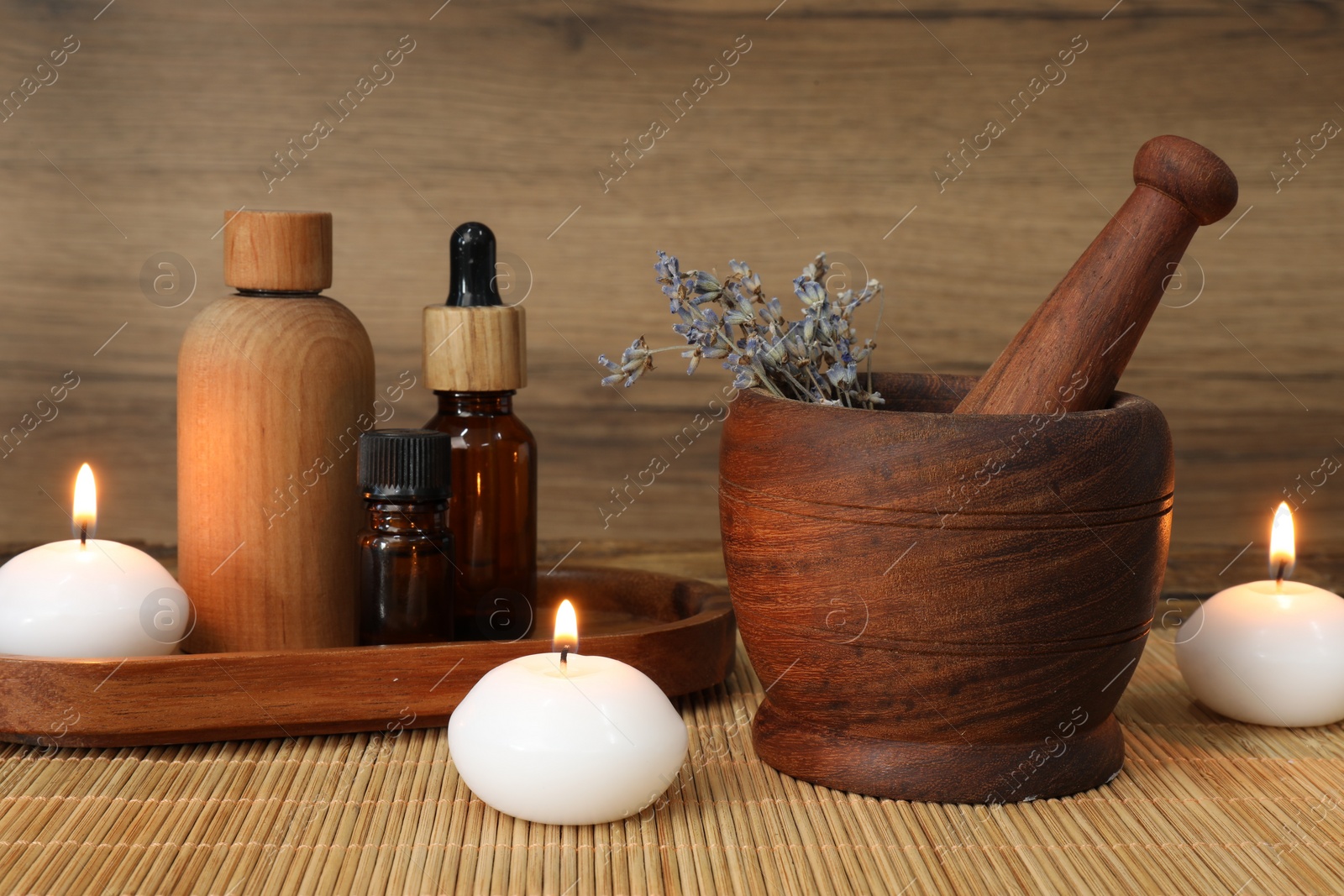 Photo of Different aromatherapy products, burning candles and mortar on table